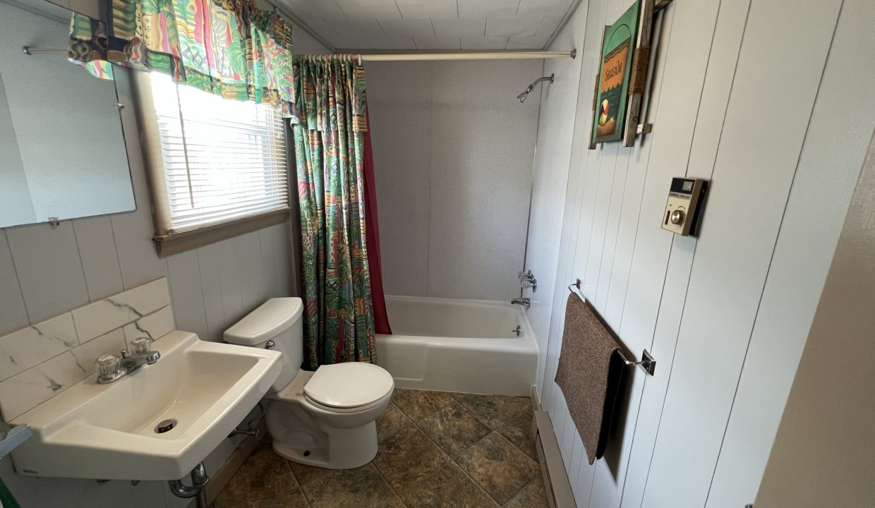 a bathroom with a toilet, sink, and bathtub.