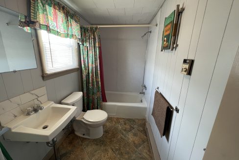 a bathroom with a toilet, sink, and bathtub.