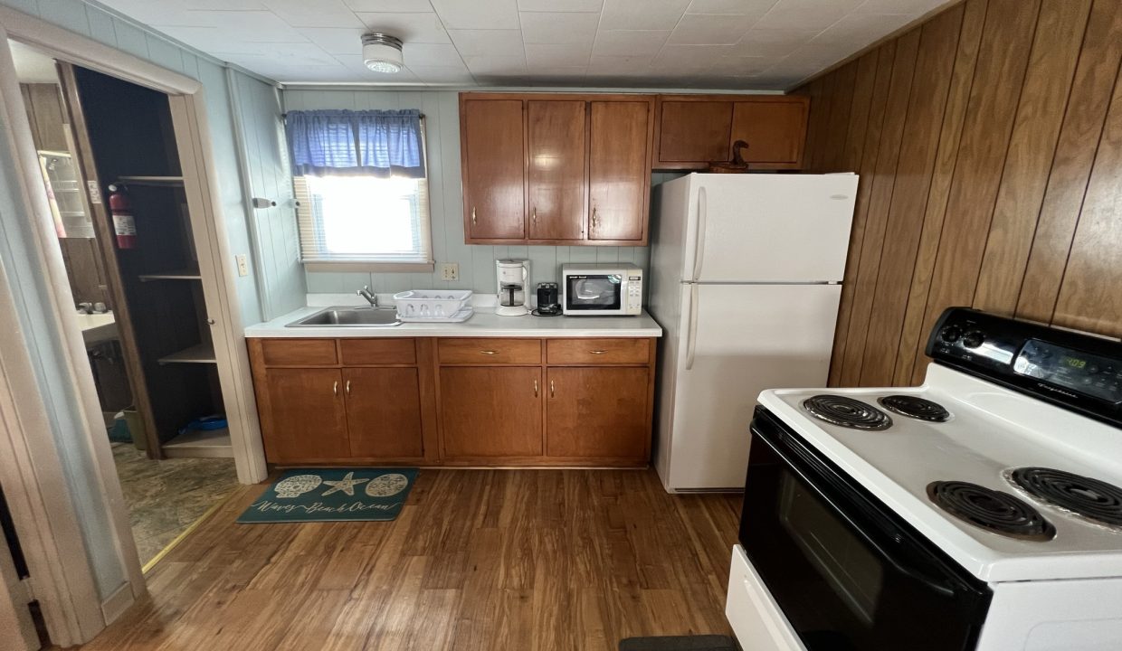 a kitchen with wood floors and white appliances.