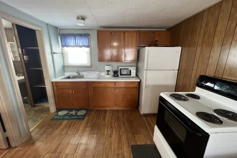 a kitchen with wood floors and white appliances.