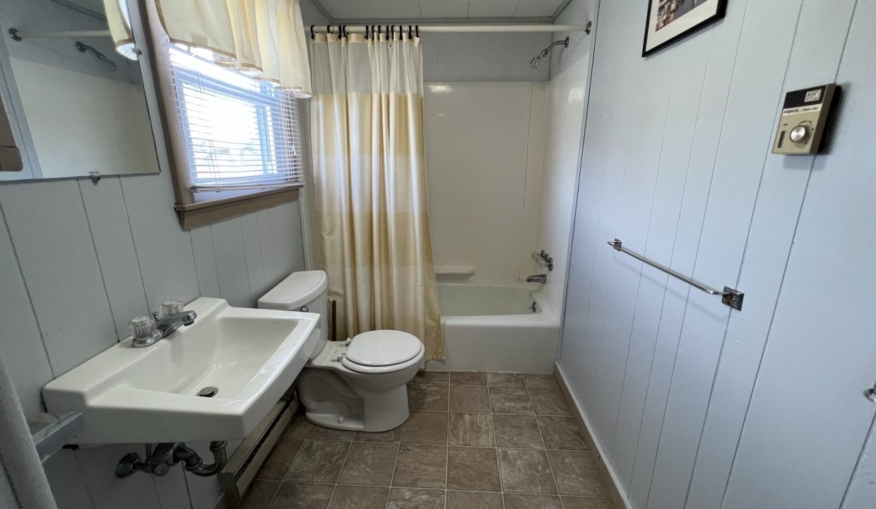 a bathroom with a toilet, sink, and bathtub.