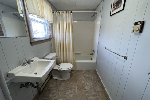 a bathroom with a toilet, sink, and bathtub.