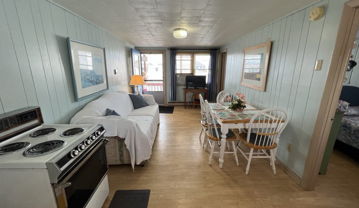 a kitchen with a stove top oven sitting next to a dining room table.