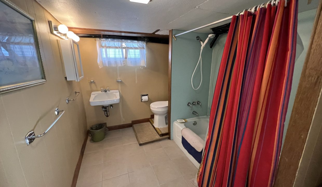 a bathroom with a shower, toilet and sink.