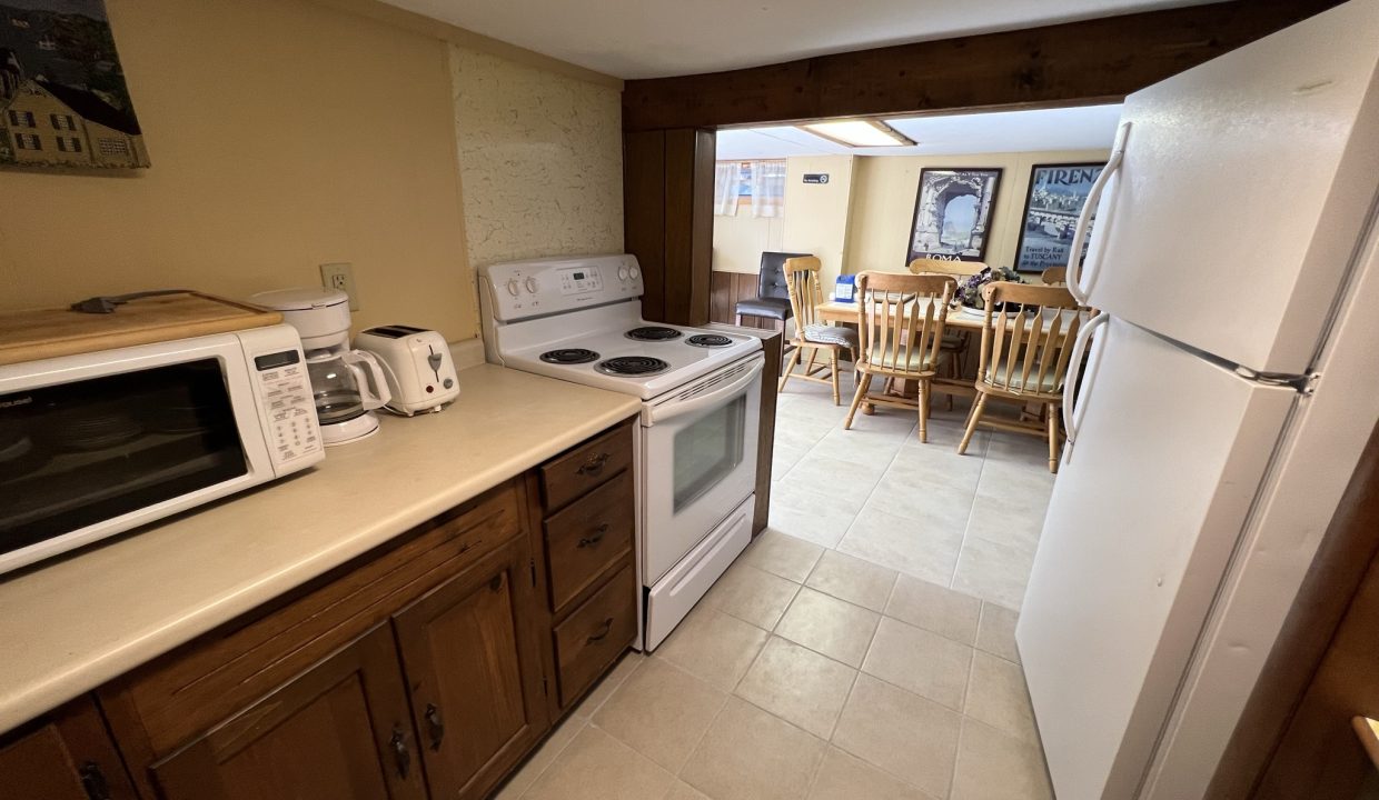 a kitchen with a white refrigerator freezer next to a stove top oven.