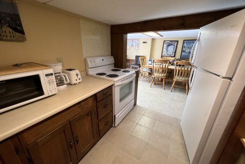 a kitchen with a white refrigerator freezer next to a stove top oven.