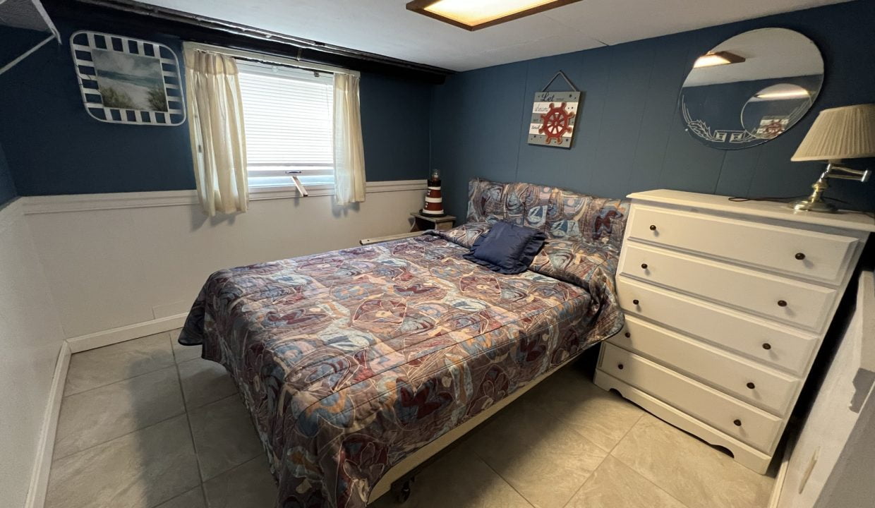 a bed room with a neatly made bed and a dresser.