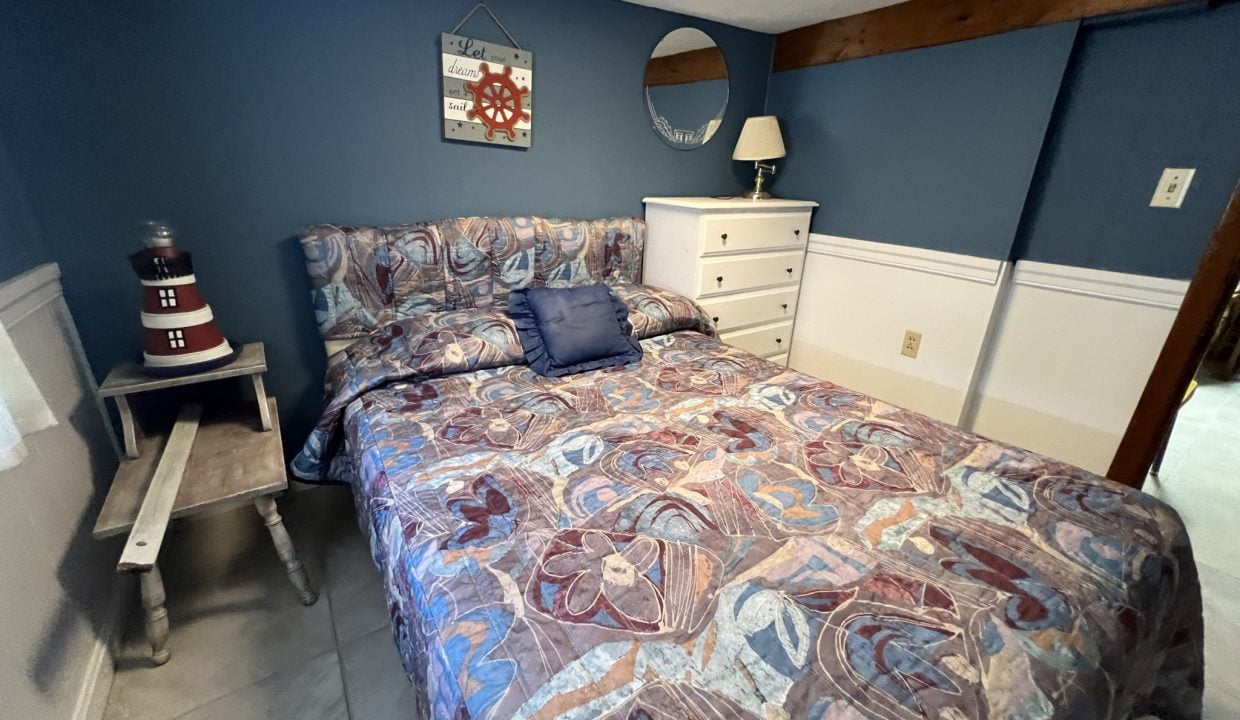 a bed room with a neatly made bed and a night stand.