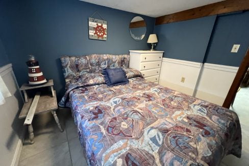 a bed room with a neatly made bed and a night stand.