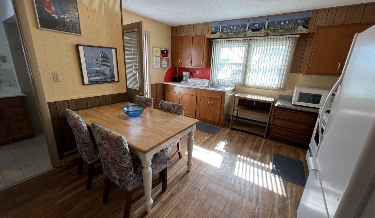 a kitchen with a table, refrigerator, stove and microwave.