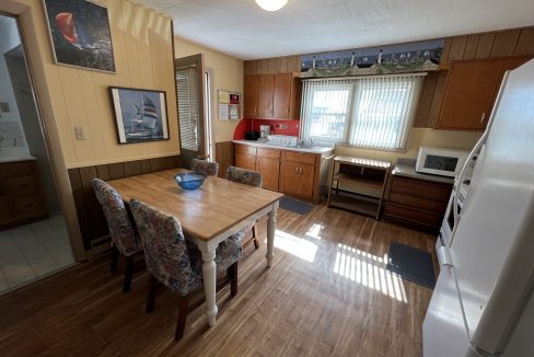 a kitchen with a table, refrigerator, stove and microwave.