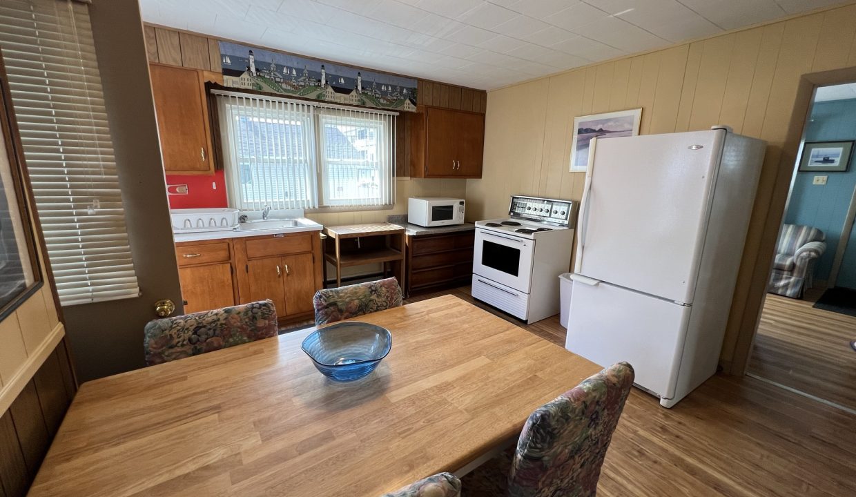 a kitchen with a table and chairs and a refrigerator.