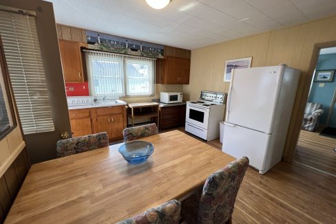 a kitchen with a table and chairs and a refrigerator.