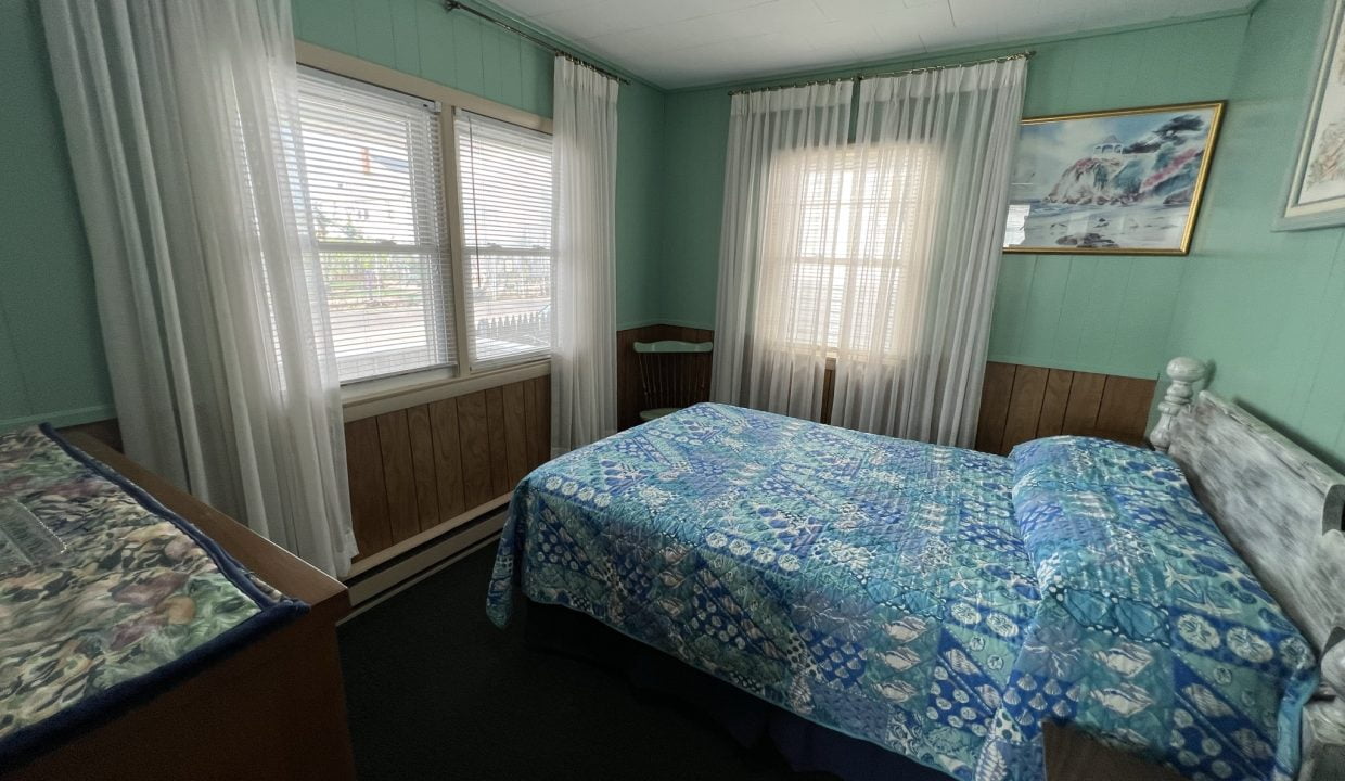 a bed room with a neatly made bed and a window.