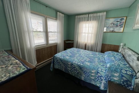 a bed room with a neatly made bed and a window.