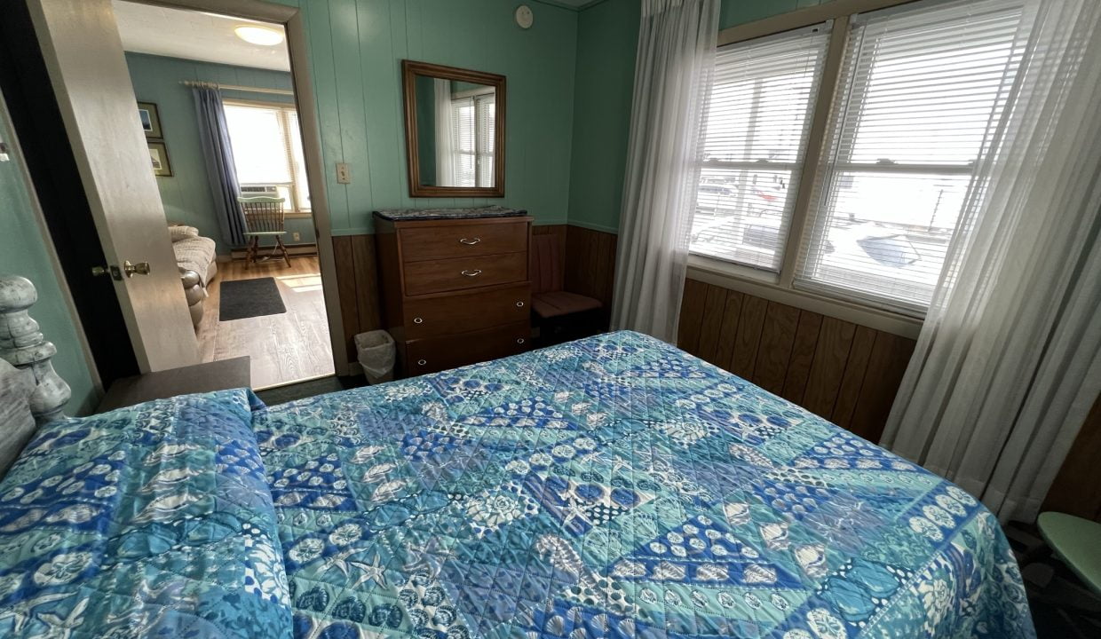 a bed room with a neatly made bed and a dresser.