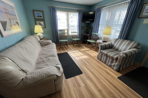 a living room filled with furniture and a hard wood floor.