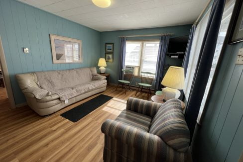 a living room filled with furniture and a lamp.