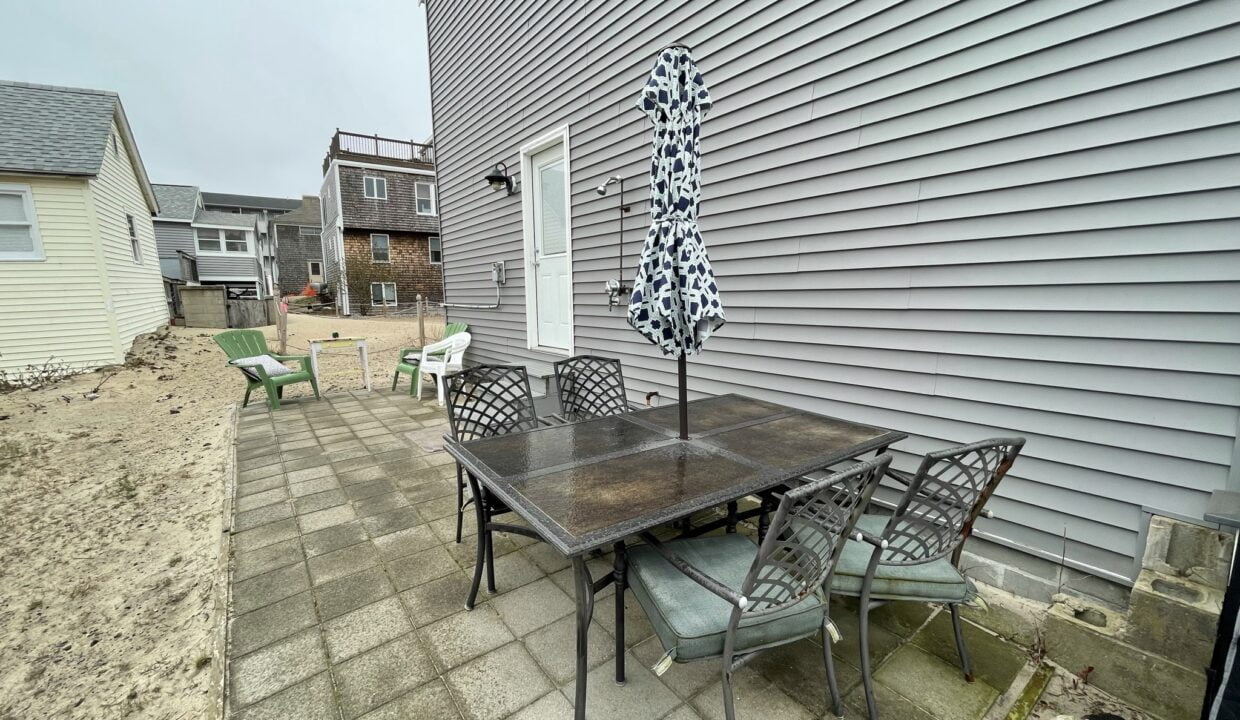 a patio with a table and chairs and an umbrella.