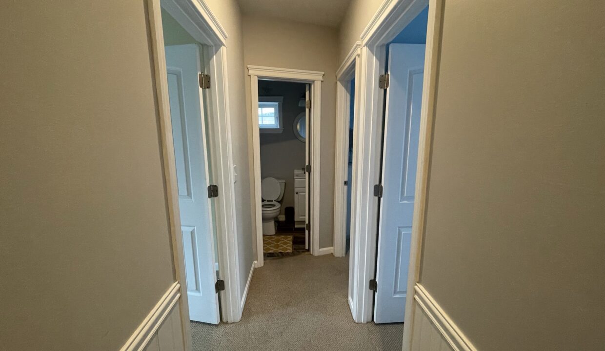 a view of a hallway through two doors.