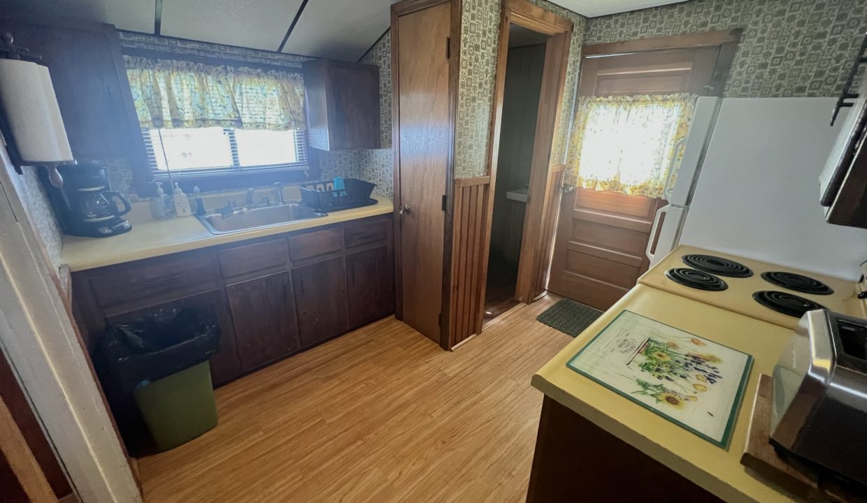 a kitchen with a stove top oven next to a window.