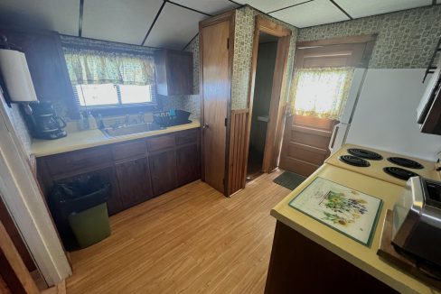 a kitchen with a stove top oven next to a window.