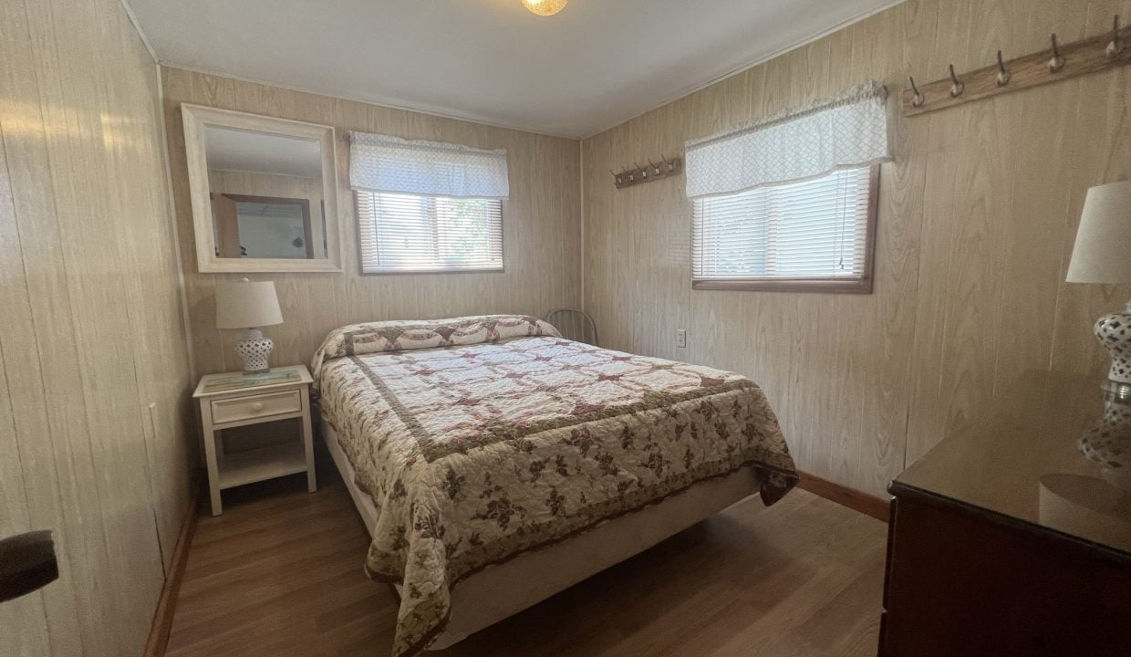 a bed room with a neatly made bed and a night stand.