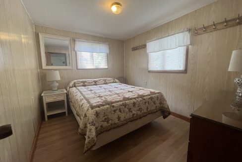 a bed room with a neatly made bed and a night stand.