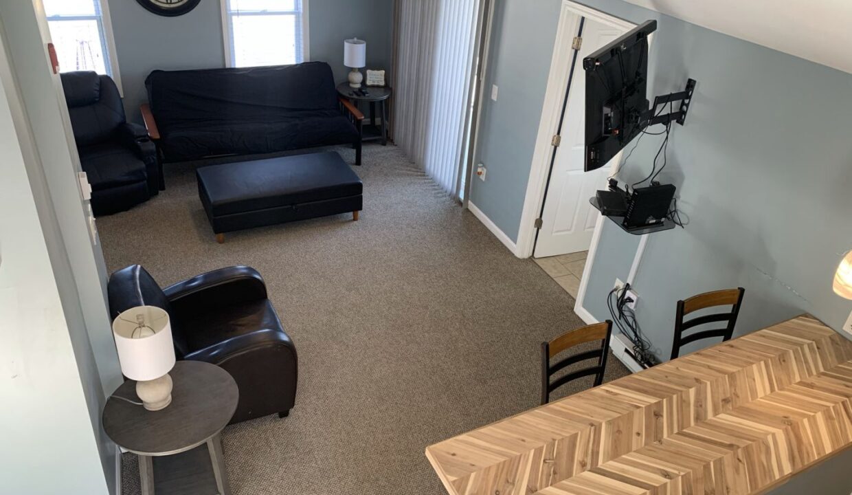 a living room with a couch, chair and television.