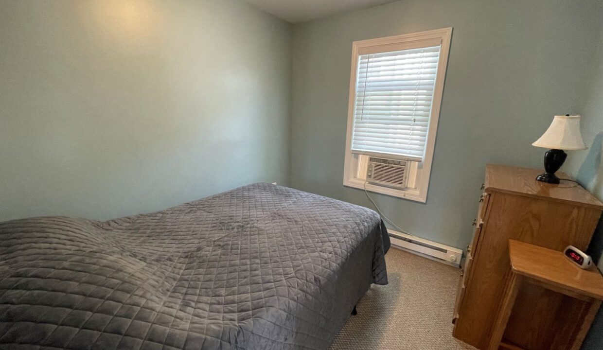 a bed sitting in a bedroom next to a window.