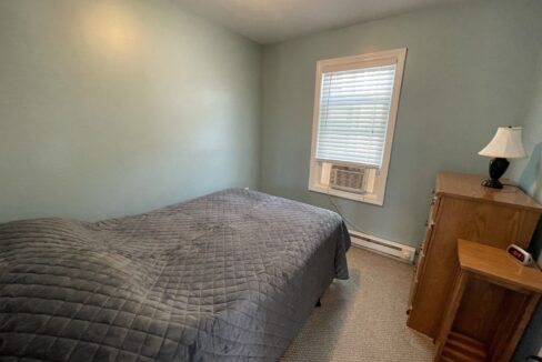 a bed sitting in a bedroom next to a window.