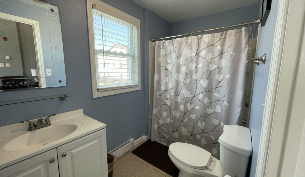 a bathroom with a sink, toilet, and shower.