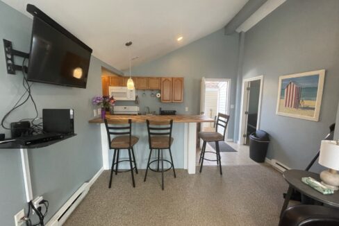 a kitchen with a bar and a television mounted on the wall.