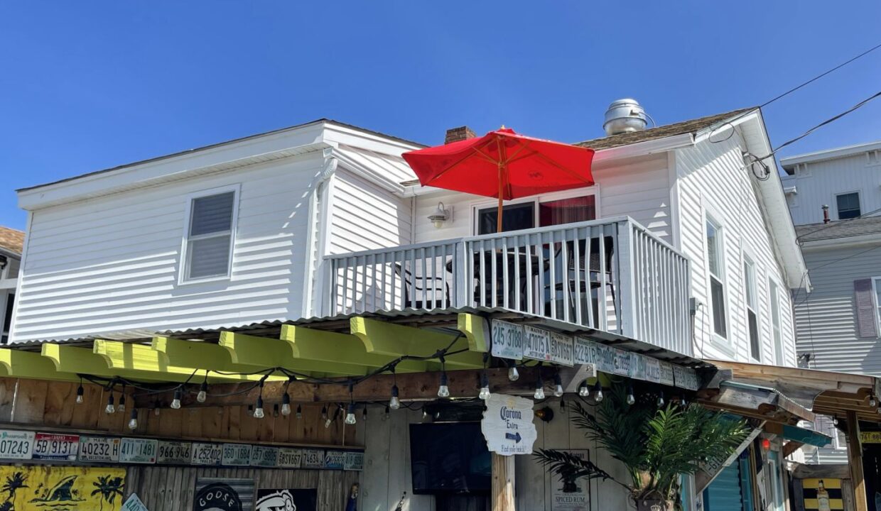 a white house with a red umbrella over it.