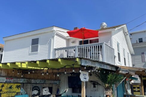 a white house with a red umbrella over it.