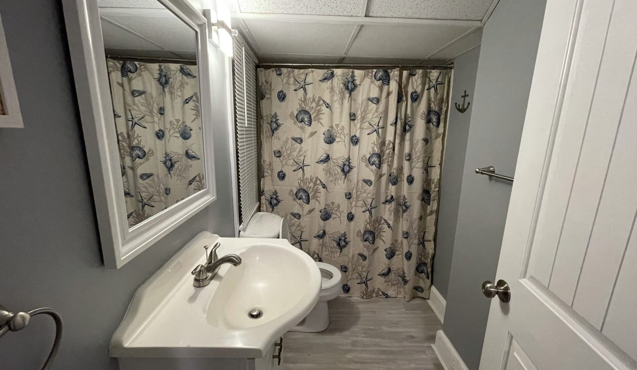 a white sink sitting under a bathroom mirror.