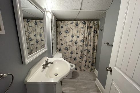 a white sink sitting under a bathroom mirror.