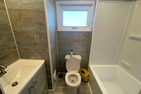 a bathroom with a toilet, sink, and bathtub.