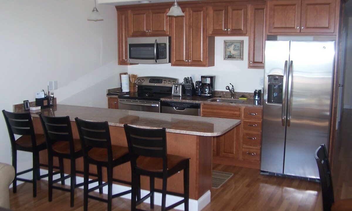 a kitchen with a refrigerator, stove, microwave, and dining table.