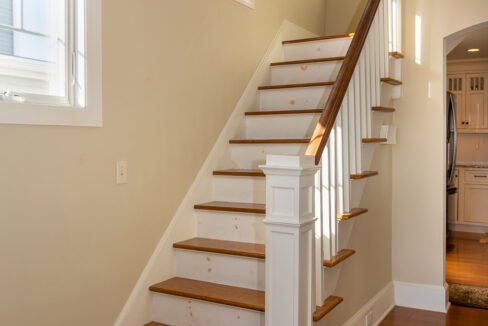 a white staircase with wooden steps in a house.