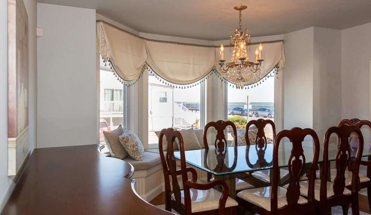 a dining room table with chairs and a chandelier.