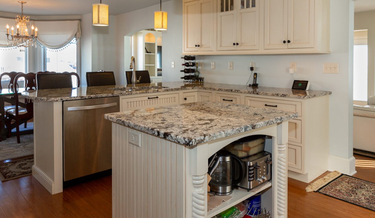 a kitchen with a center island with a marble top.