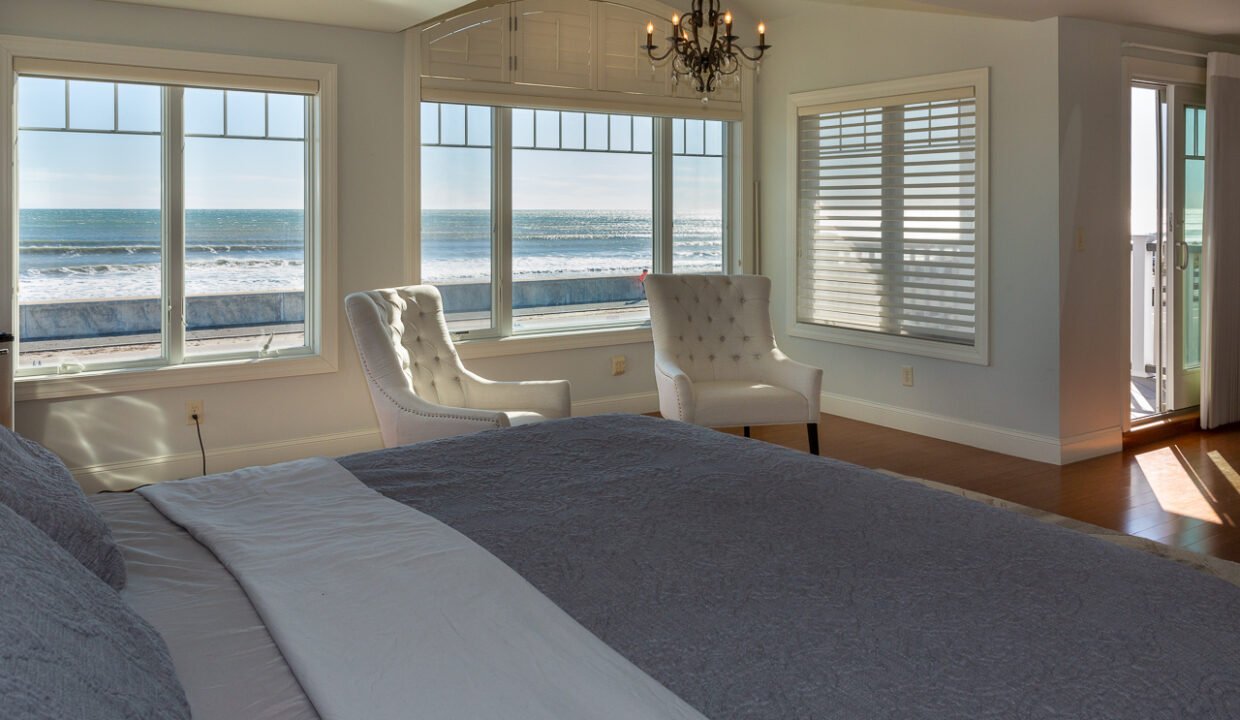 a bedroom with a large bed and a chandelier.