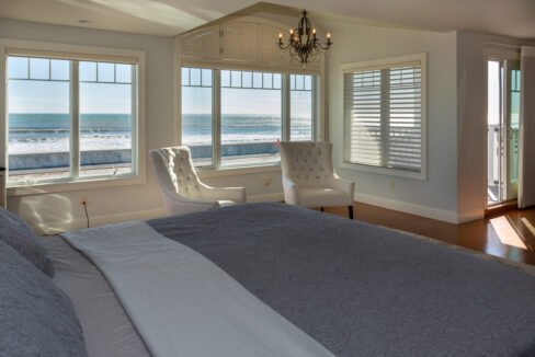 a bedroom with a large bed and a chandelier.