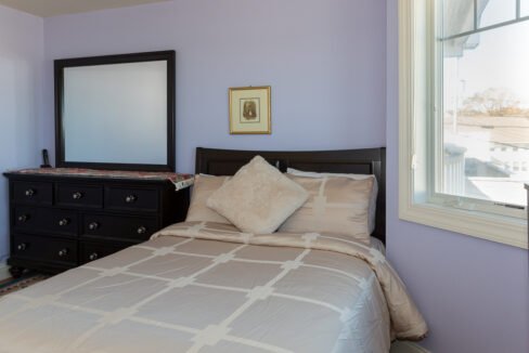 a bedroom with a bed, dresser and mirror.