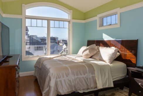 a bedroom with a bed and a large window.