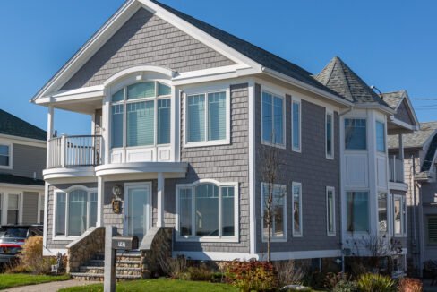 a gray house with white trim and windows.