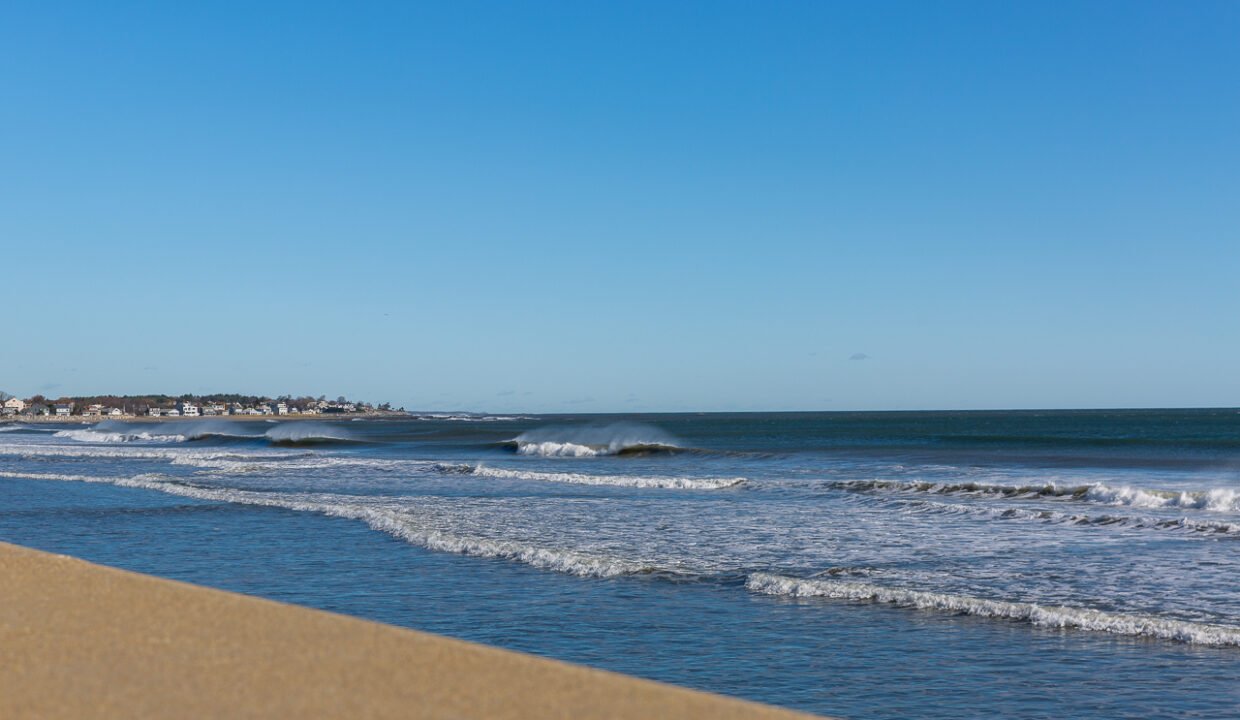 a sandy beach with waves coming in to shore.