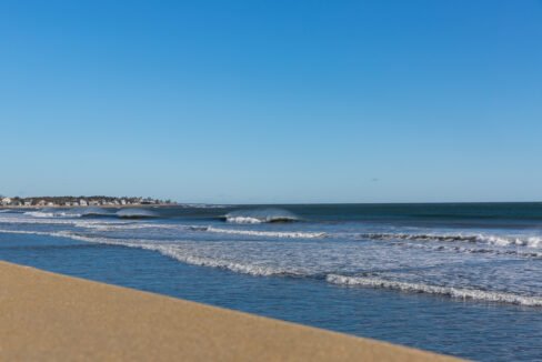 a sandy beach with waves coming in to shore.