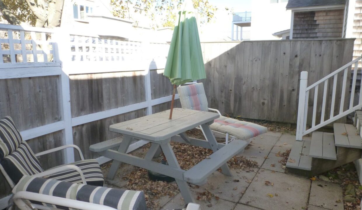 a patio with a table and chairs and an umbrella.